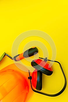 Protective equipment and tools in a bag for the builder on a yellow background