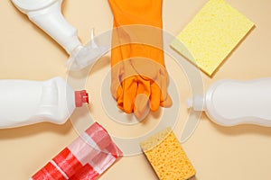 Protective gloves with bottles of washing and cleaning liquids on the blue background