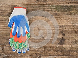 Protective gloves painter on wooden background. The view from the top.