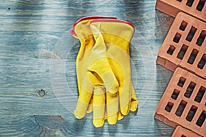 Protective gloves red bricks on wooden board construction concep