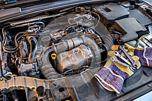 Protective gloves with spanners at car engine