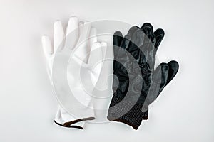 Protective gloves for workers, top view. The concept of safety at work. White and black protective gloves on a white background.