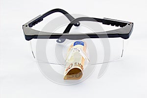 Protective goggles and fifty euro banknote