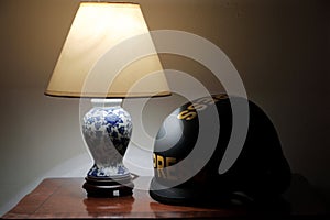 Protective helmet with `Press` inscriptions lowered on a table under a lit table lamp