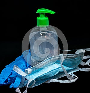 Protective mask , blue latex gloves and transparent white plastic botle with sanitizer fluid