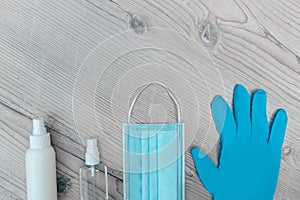 Protective mask, gloves and antiseptics on a wooden background