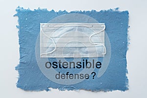 Protective medical mask on a blue background. The inscription `ostensible defense?`, a copy of the space photo