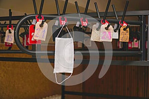 A protective medical mask hangs on a hanger in the wardrobe