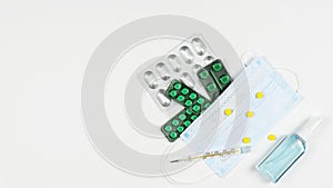 Protective medicine mask, antiseptic, thermometer and pills, flat lay. Concept of doctor table and health care