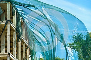 Protective mesh on scaffolding torn by hurricane wind. Background with selective focus