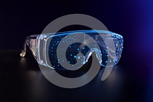 protective plastic glasses under uv light with droplets on surface