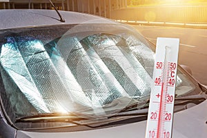 Protective reflective surface under the windshield of the passenger car parked on a hot day, heated by the sun`s rays. The