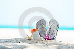 Protective sunscreen or sunblock and sunbath lotion for healthy care skin woman in white plastic bottles with sandal, starfish on