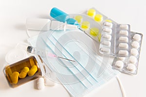 Protective surgical mask,spray, pills, drops and syringe on white background. photo