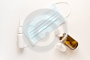 Protective surgical mask, syringe on a white table photo