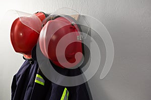 Protective workwear and hard hat hanging on hook