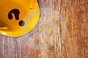 Protective yellow construction helmet with question mark