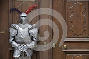 The protector - Armoured medieval knight standing in front of an old door