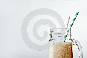 Protein cocktail with milk, vanilla in a glass jar with straws. Sports nutrition