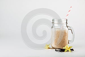 Protein cocktail with milk, vanilla in a glass jar with straws. Sports nutrition