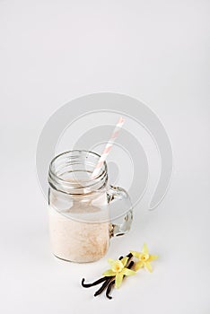 Protein cocktail with milk, vanilla in a glass jar with straws. Sports nutrition