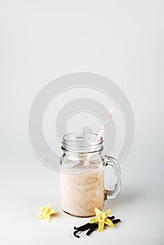 Protein cocktail with milk, vanilla in a glass jar with straws. Sports nutrition