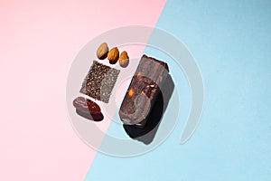 Protein date fruit candy bars fitness with nuts and fruit almond and chia poppy seeds top view on blue pink background