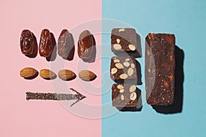 Protein date fruit candy bars fitness with nuts and fruit almond and chia poppy seeds top view on blue pink background