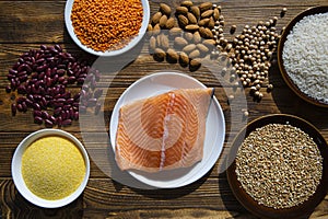 Protein food on wooden rustic background. Salmon, assortment of beans and cereals