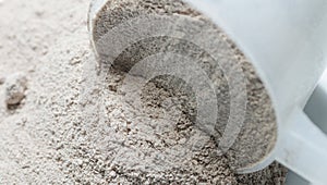 Protein powder chocolate deluxe flavour on scoop closeup isolat