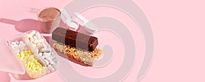 Protein powder, scoop, energetic musli bars, vitamin pills, gainer on pink background with shadow - concept of sport diet,