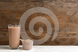 Protein shake and powder on white table, space for text