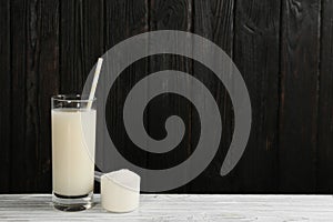 Protein shake and powder on white table, space for text