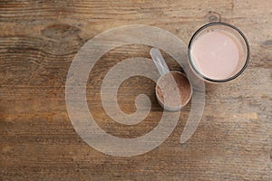 Protein shake and powder on wooden table, flat lay