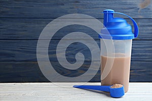 Protein shake and powder on table, space for text