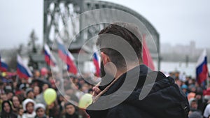 Protest crowd in Russia. Rally with Russian banners, speaker on stage with mike.