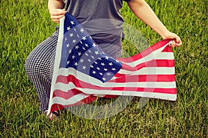 Protest in the US park grass, woman kneel. USA flag, kneeling on green background