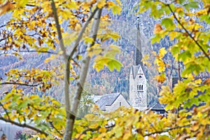 Protestant church through yellow leaves in Hallstatt