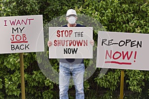Protester with cap and medical protection mask demonstrate against stay-at-home orders due to the COVID-19 pandemic