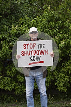 Protester with cap and sunglasses demonstrate against stay-at-home orders due to the COVID-19 pandemic