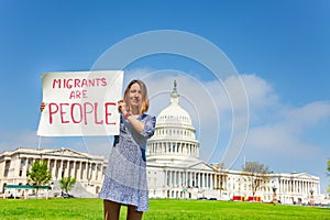 Protester holding sign saying migrants are people