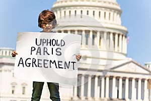 Protester holding sign uphold Paris agreement in hands