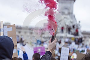 A protestor holds a smoke bomb at a political demonstration