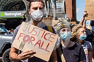 Protestors March and Hold Up Signs Calling for Justice For All at Protest for George Floyd