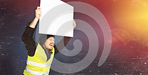 Protests yellow vests. Young man is holding a poster with lights on blue background