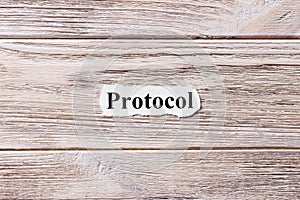 PROTOCOL of the word on paper. concept. Words of PROTOCOL on a wooden background