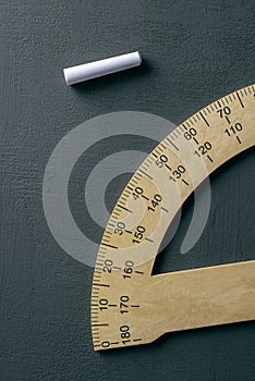 Protractor and piece of chalk on a chalkboard
