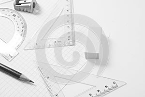 Protractor, rulers, pencil and eraser on squared paper photo