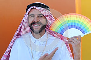 Proud Arabic gay man holding a fan with the rainbow flag