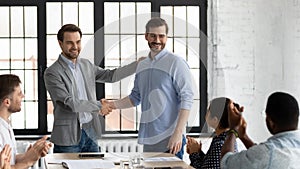 Proud boss encouraging and thanking happy employee for good job